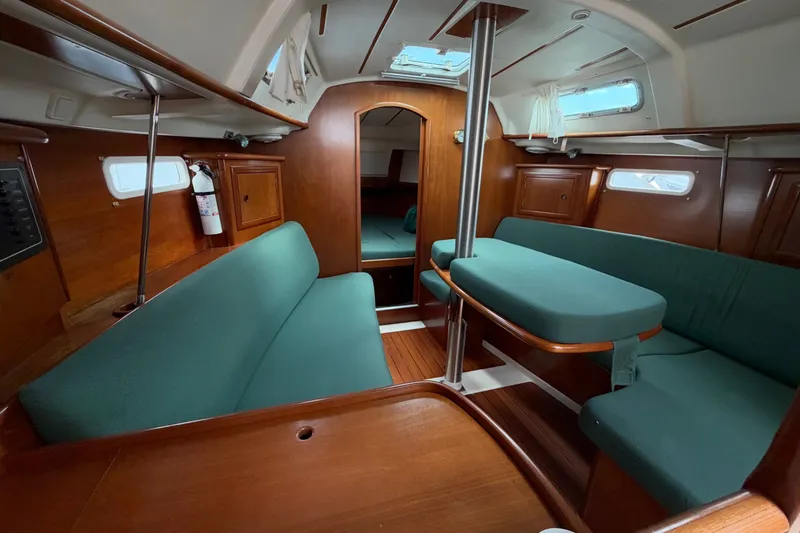 Slide: The Image of Interior of 2001 Beneteau Oceanis 331 sailboat with green seating and wooden finishes. - 11