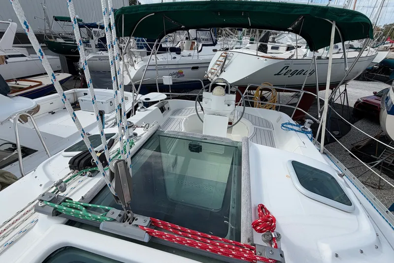 Slide: The Image of 2001 Beneteau Oceanis 331 sailboat with green canopy, docked among other boats. - 10