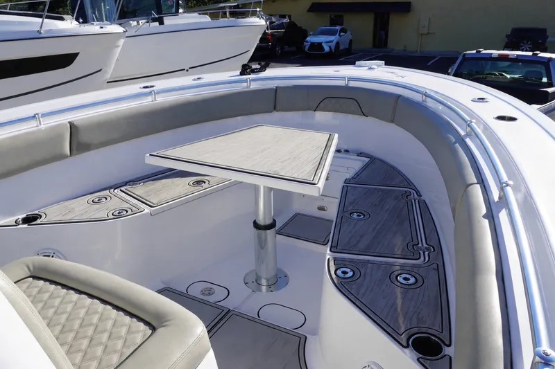Slide: The Image of 2022 Sportsman Open 282TE Center Console boat interior with seating and table setup. - 17