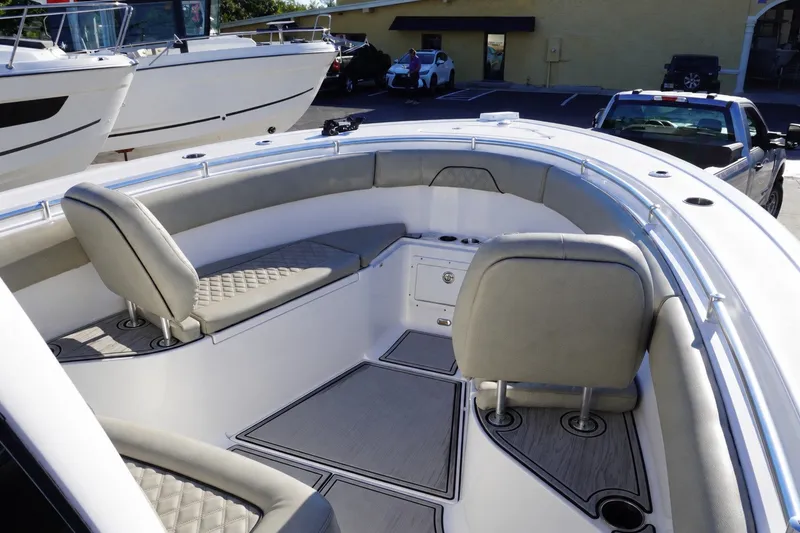 Slide: The Image of 2022 Sportsman Open 282TE Center Console boat interior with cushioned seating and storage. - 18