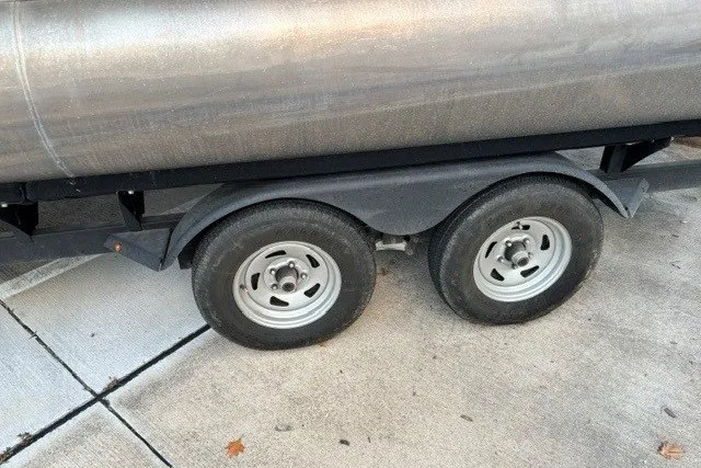 Slide: The Image of Trailer wheels of a 2021 Sun Tracker Party Barge 24 DLX on pavement. - 17