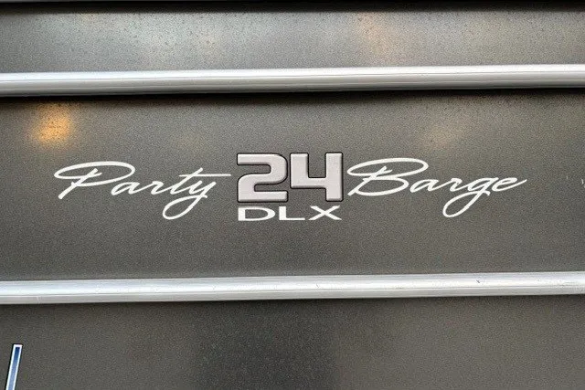 Slide: The Image of 2021 Sun Tracker Party Barge 24 DLX logo on metallic surface. - 18