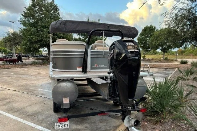 Slide: The Image of 2021 Sun Tracker Party Barge 24 DLX pontoon boat parked in a lot, rear view. - 14