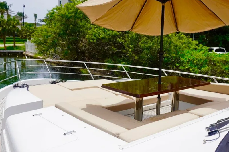 Slide: The Image of Luxurious 2015 Azimut 84 yacht deck with seating and umbrella, surrounded by lush greenery. - 23