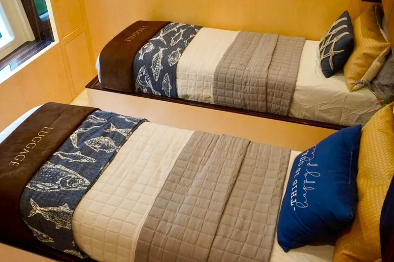 Slide: The Image of Twin beds in a 2015 Azimut 84 yacht cabin, featuring nautical-themed bedding. - 14