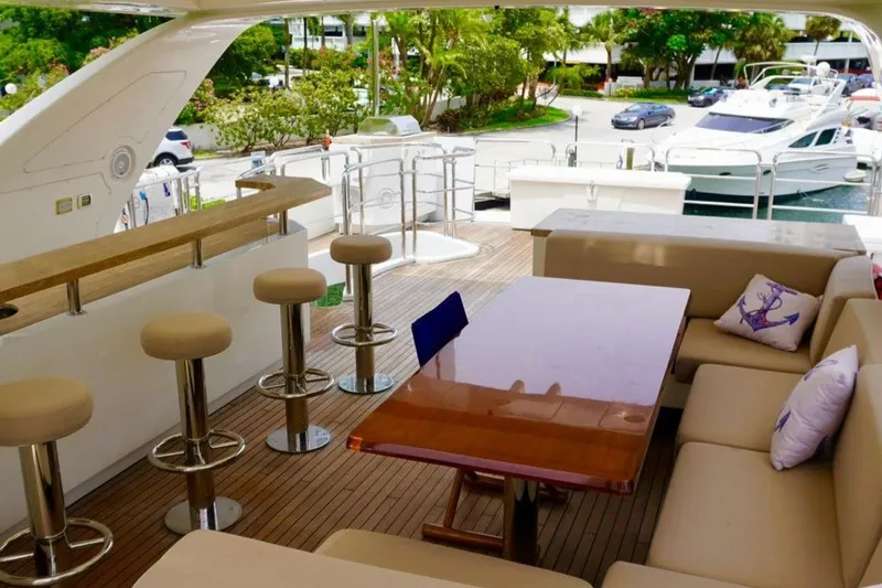 Slide: The Image of Luxurious 2015 Azimut 84 yacht deck with seating, bar stools, and scenic marina view. - 19