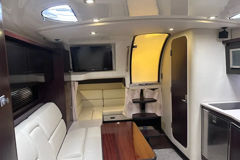 Slide: The Image of Interior of a 2012 Monterey 340 Sport Yacht with modern furnishings and a cozy seating area. - 16