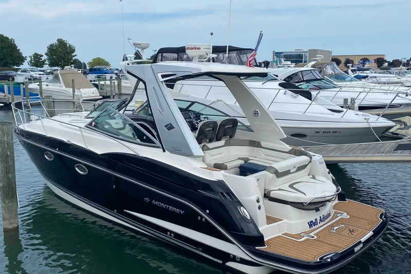 The Image of 2012 Monterey 340 Sport Yacht docked at marina, featuring sleek black and white design. - 0