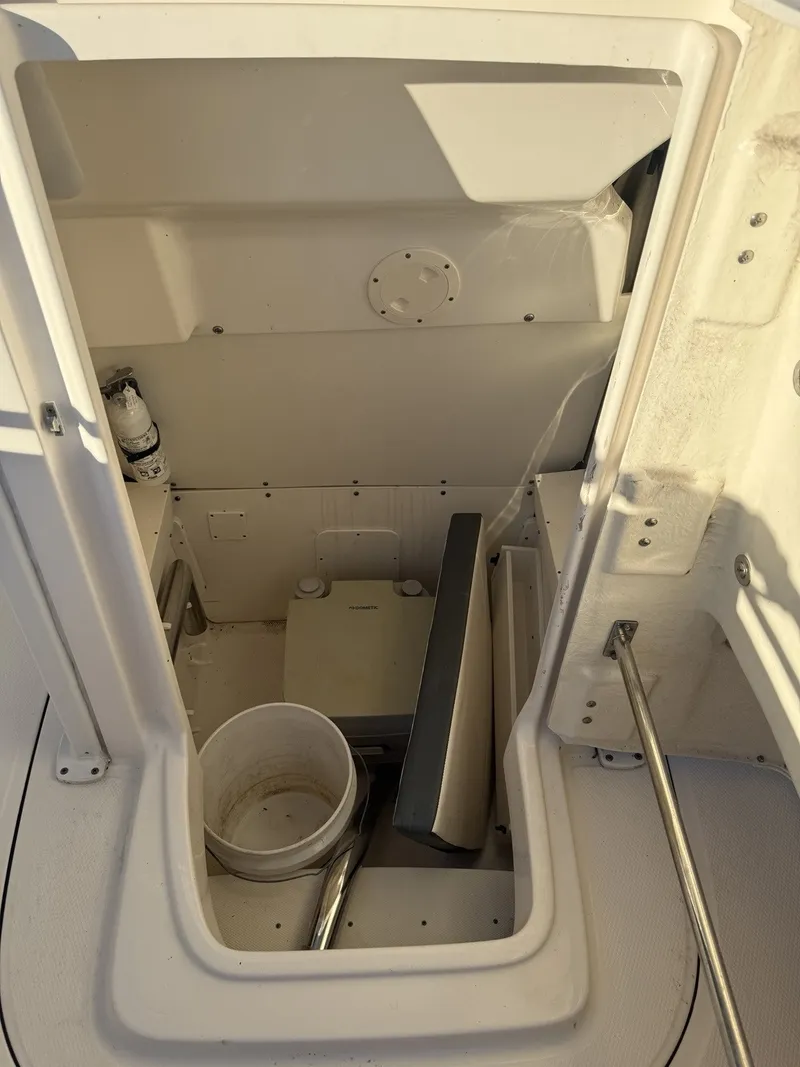 Slide: The Image of Interior view of a 2021 Robalo R230 Center Console boat with storage space and a bucket. - 14