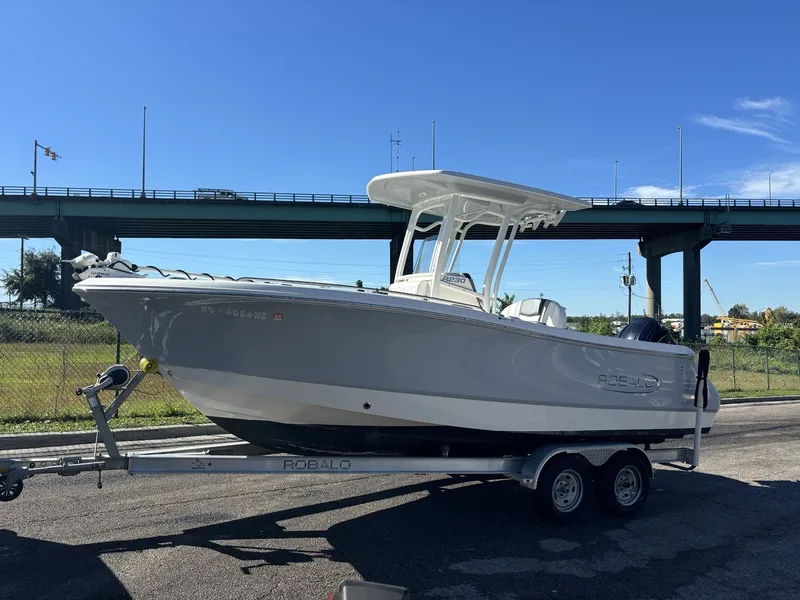 Slide: The Image of A 2021 Robalo R230 Center Console boat on a trailer under a bridge. - 15