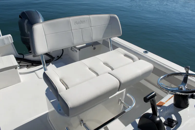 Slide: The Image of 2023 Parker 2300 Special Edition boat interior with cushioned seating and steering wheel. - 16