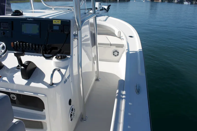 Slide: The Image of 2023 Parker 2300 Special Edition boat interior with control panel and seating, on calm water. - 22