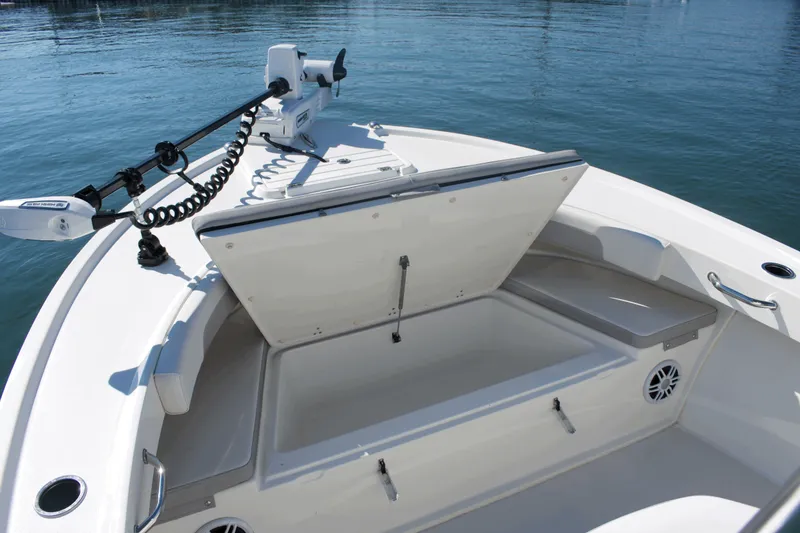 Slide: The Image of 2023 Parker 2300 Special Edition boat with open storage compartment and trolling motor on calm water. - 7