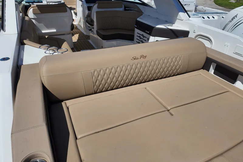 Slide: The Image of 2024 Sea Ray SLX 310 boat interior with luxurious beige seating and cup holders. - 16