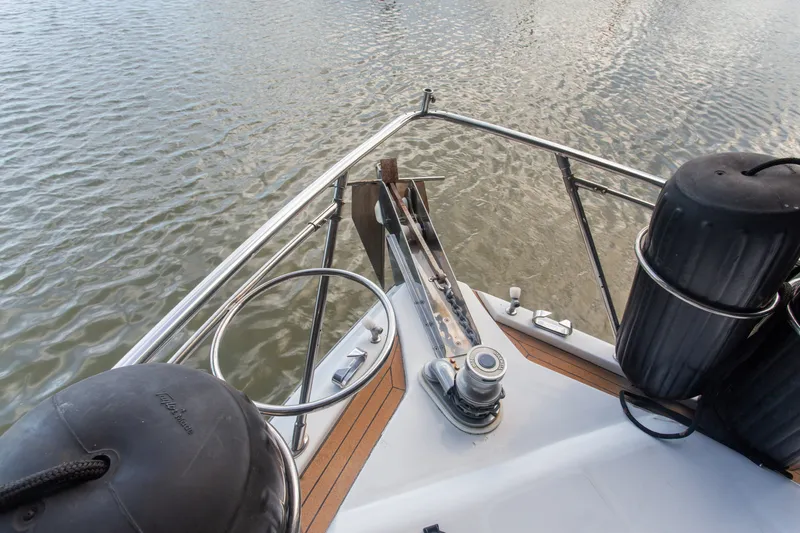 Slide: The Image of Bow view of 1993 Johnson 56 Motor Yacht with anchor and fenders. - 31