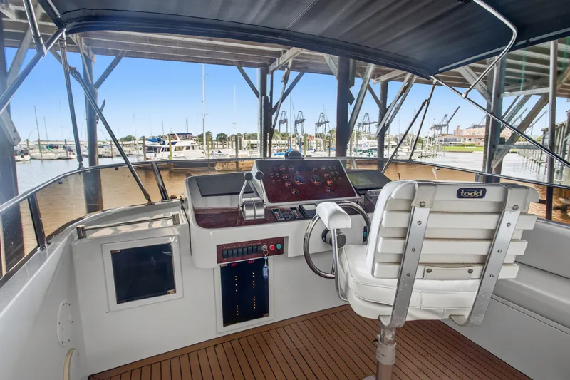 Slide: The Image of Cockpit of 1993 Johnson 56 Motor Yacht with steering wheel and control panel. - 34