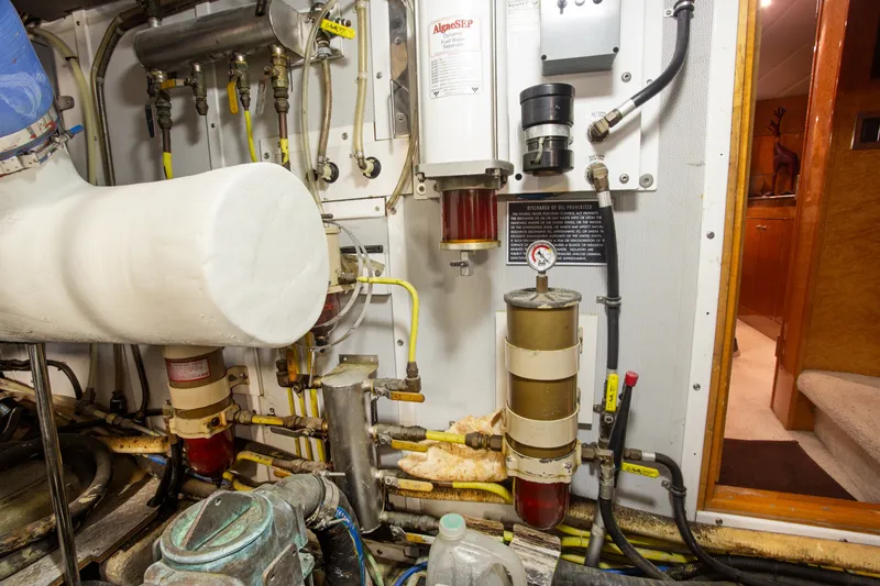 Slide: The Image of Engine room of a 1993 Johnson 56 Motor Yacht, showcasing mechanical components and piping. - 46