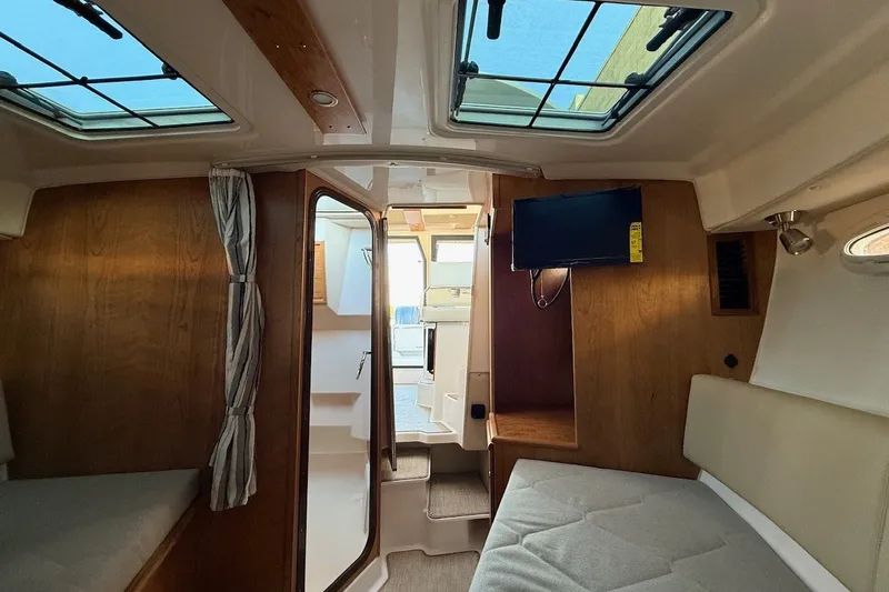 Slide: The Image of Interior of 2027 Cutwater C-288 Coupe, featuring cozy seating and a mounted TV. - 19