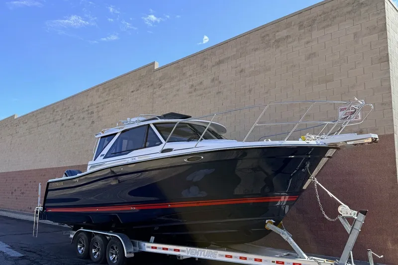 The Image of 2027 Cutwater C-288 Coupe boat on trailer, parked beside a brick wall. - 0