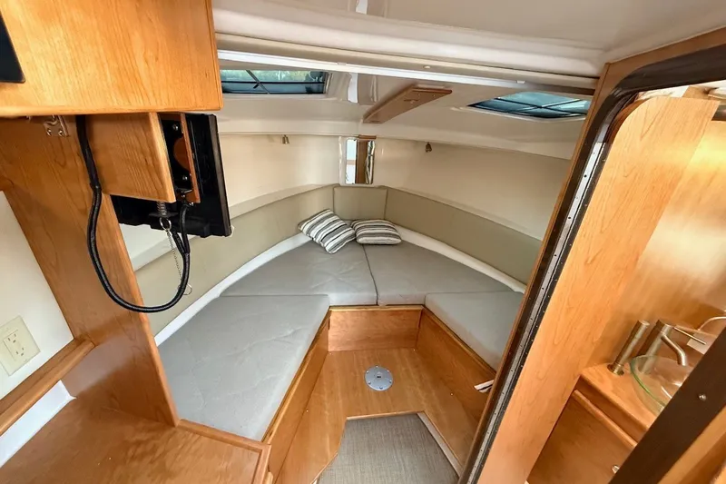 Slide: The Image of Interior of 2027 Cutwater C-288 Coupe, featuring cozy cabin with cushions and wood accents. - 16