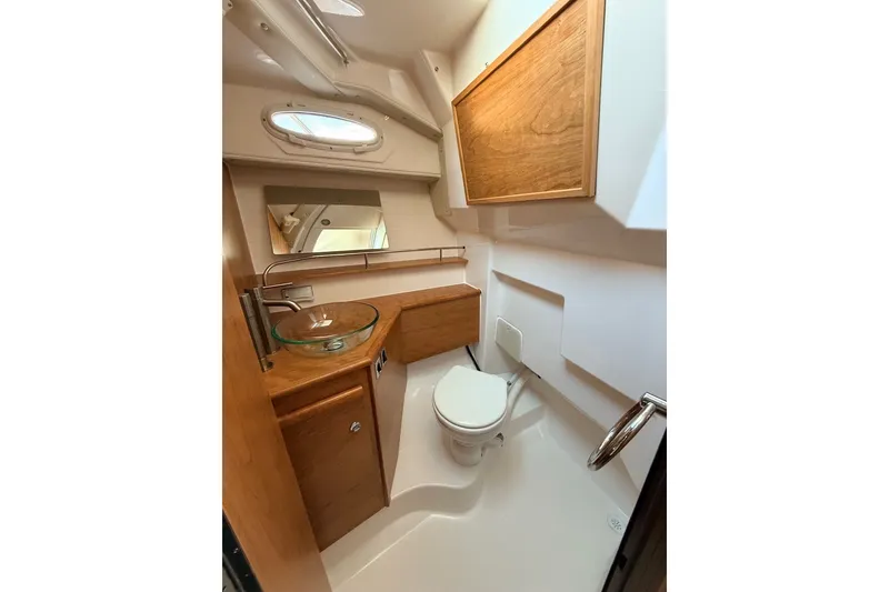Slide: The Image of 2027 Cutwater C-288 Coupe bathroom with modern fixtures, glass sink, and wooden cabinetry. - 17