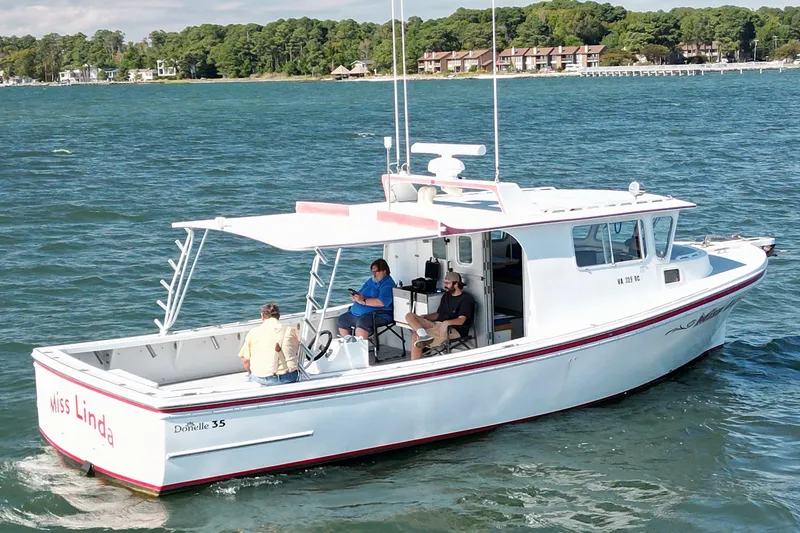 The Image of 2002 Donelle Express Down East Lobster Boat cruising on a scenic waterway. - 0