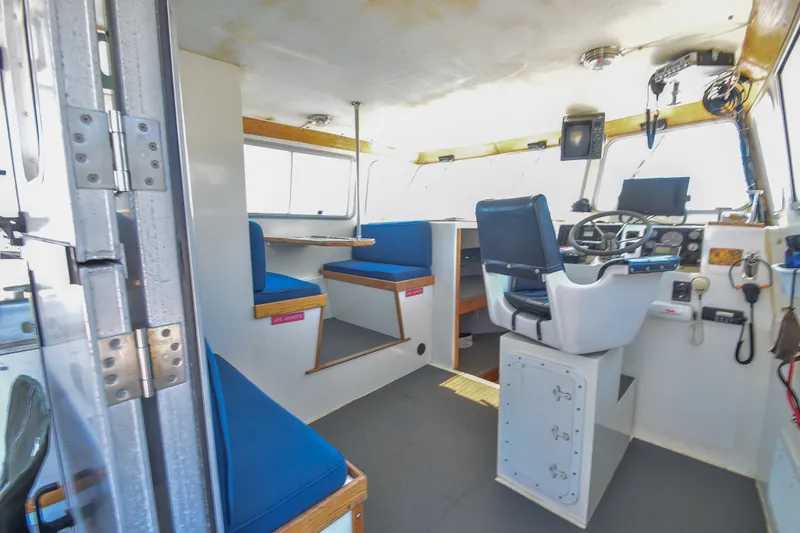 Slide: The Image of Interior of a 2002 Donelle Express Down East Lobster Boat with blue seating and control panel. - 6