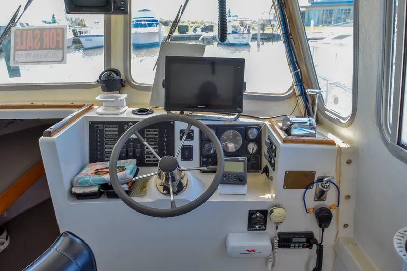 Slide: The Image of 2002 Donelle Express Down East Lobster Boat helm with steering wheel and navigation equipment. - 12