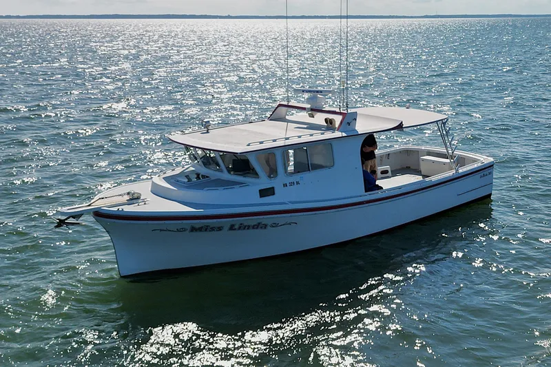 Slide: The Image of 2002 Donelle Express Down East Lobster Boat on sparkling water, named "Miss Linda." - 28