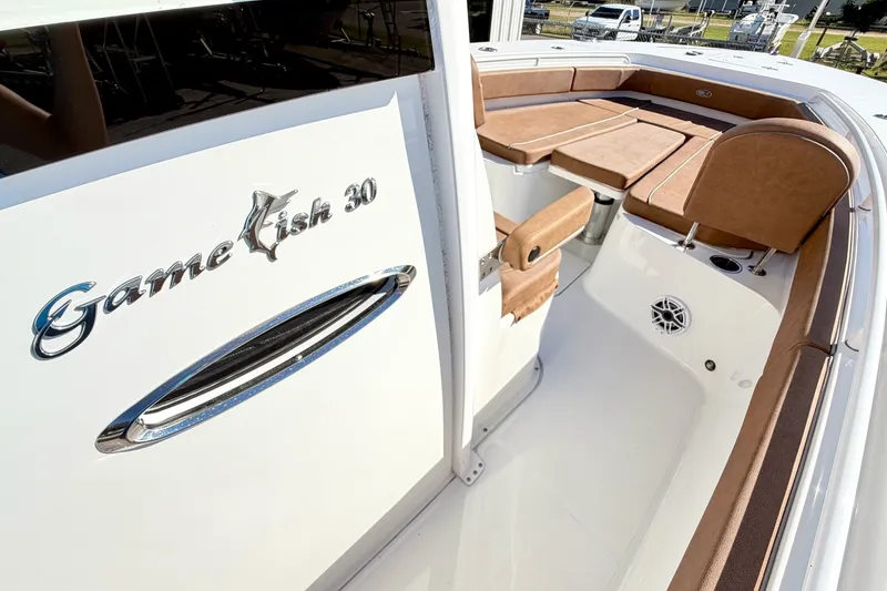 Slide: The Image of 2025 Sea Hunt Gamefish 30FS boat interior with brown seating and sleek design. - 24