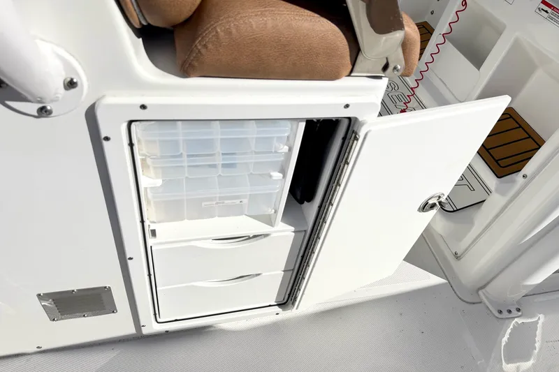 Slide: The Image of Storage compartment on a 2025 Sea Hunt Gamefish 30FS boat with open door and drawers. - 18