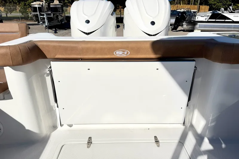 Slide: The Image of 2025 Sea Hunt Gamefish 30FS boat interior with cushioned seating and storage compartment. - 10