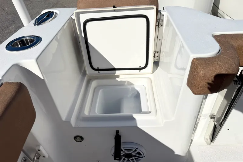 Slide: The Image of Open storage compartment on 2025 Sea Hunt Gamefish 30FS boat with cup holders and cushioned seating. - 9