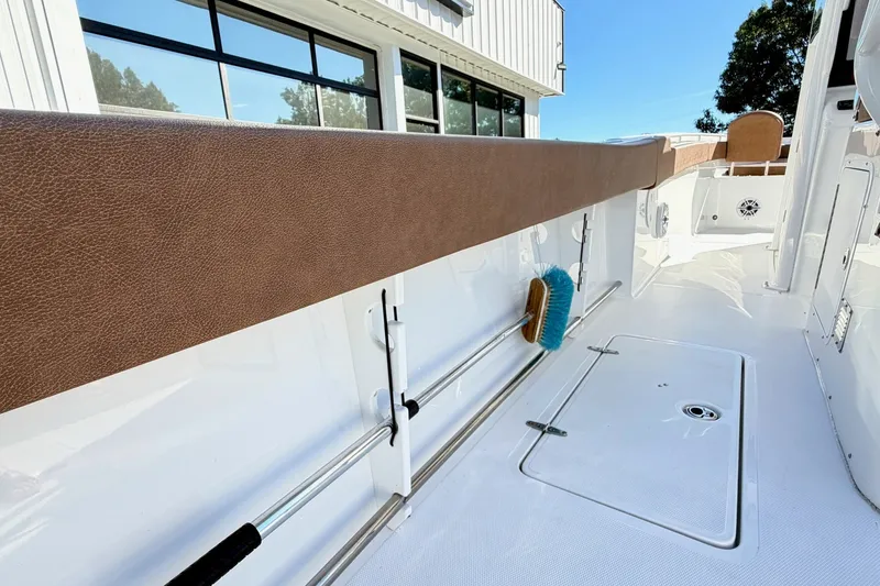 Slide: The Image of 2025 Sea Hunt Gamefish 30FS boat interior with storage and cleaning brush. - 5