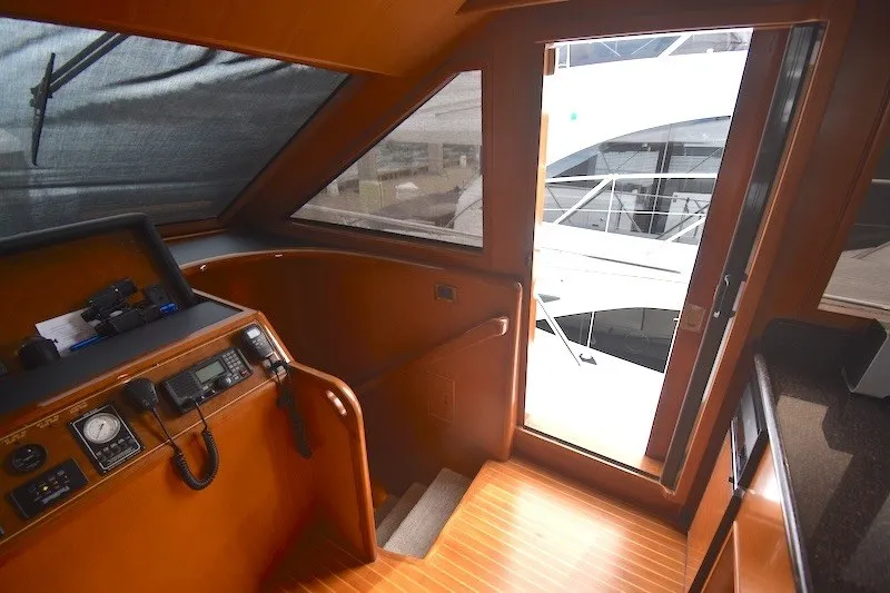 Slide: The Image of 2004 Ocean Alexander 58 Pilothouse interior with helm station and exit door. - 16