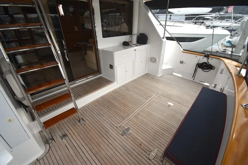 Slide: The Image of 2004 Ocean Alexander 58 Pilothouse yacht deck with wooden flooring and seating area. - 7