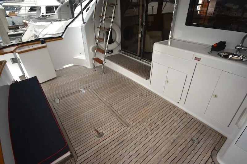 Slide: The Image of 2004 Ocean Alexander 58 Pilothouse yacht deck with seating, sink, and ladder. - 6