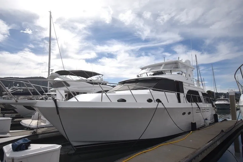 Slide: The Image of 2004 Ocean Alexander 58 Pilothouse yacht docked under a partly cloudy sky. - 2