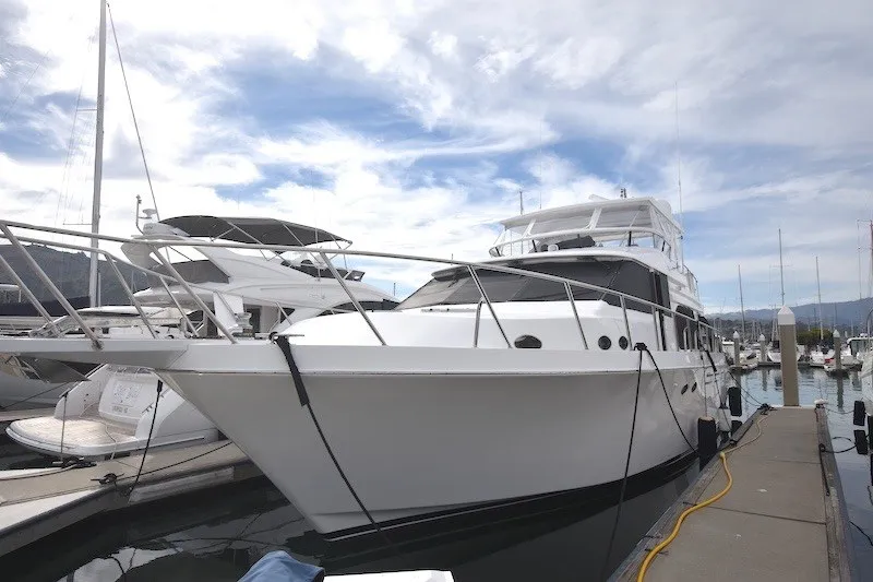 The Image of 2004 Ocean Alexander 58 Pilothouse yacht docked at marina under cloudy sky. - 1