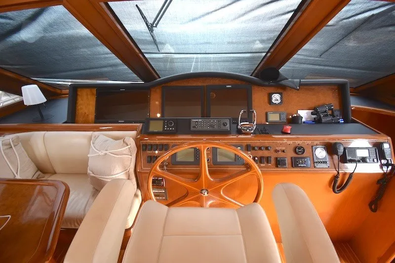 Slide: The Image of 2004 Ocean Alexander 58 Pilothouse helm with wooden steering wheel and navigation instruments. - 17