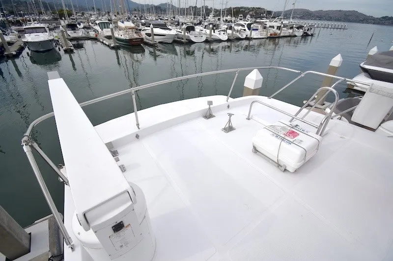 Slide: The Image of 2004 Ocean Alexander 58 Pilothouse yacht docked at marina, showcasing spacious deck. - 33