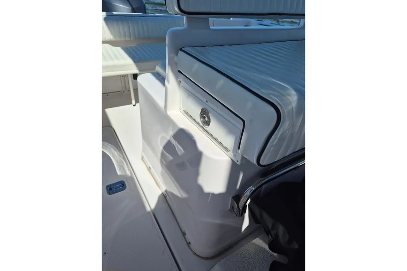 Slide: The Image of 2000 Pro-Line 24 Sport boat interior with white seating and storage compartment. - 40