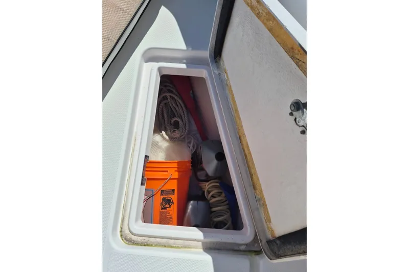 Slide: The Image of Open storage compartment on 2000 Pro-Line 24 Sport boat with ropes and equipment. - 33