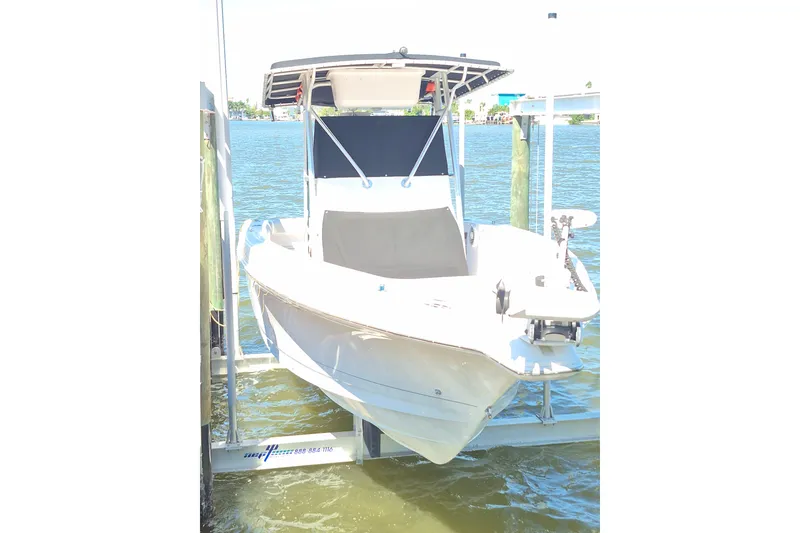 Slide: The Image of 2000 Pro-Line 24 Sport boat on lift, docked by the water. - 47