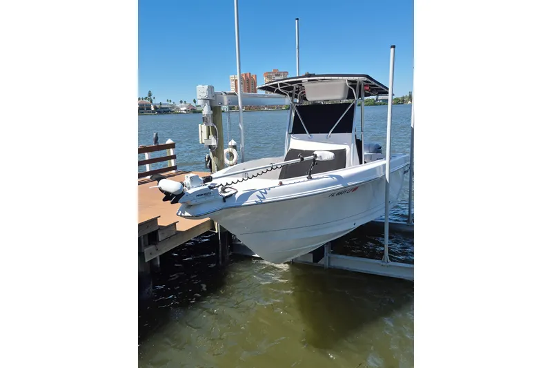 Slide: The Image of 2000 Pro-Line 24 Sport boat docked on a lift by the waterfront. - 46