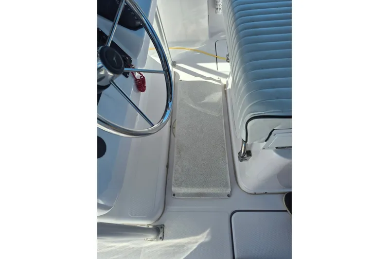 Slide: The Image of Interior view of a 2000 Pro-Line 24 Sport boat, featuring steering wheel and seating. - 21