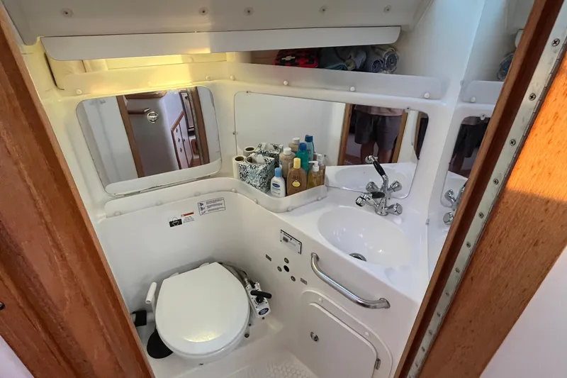 Slide: The Image of Compact bathroom in a 2005 Catalina 320 sailboat with sink, toilet, and toiletries. - 8