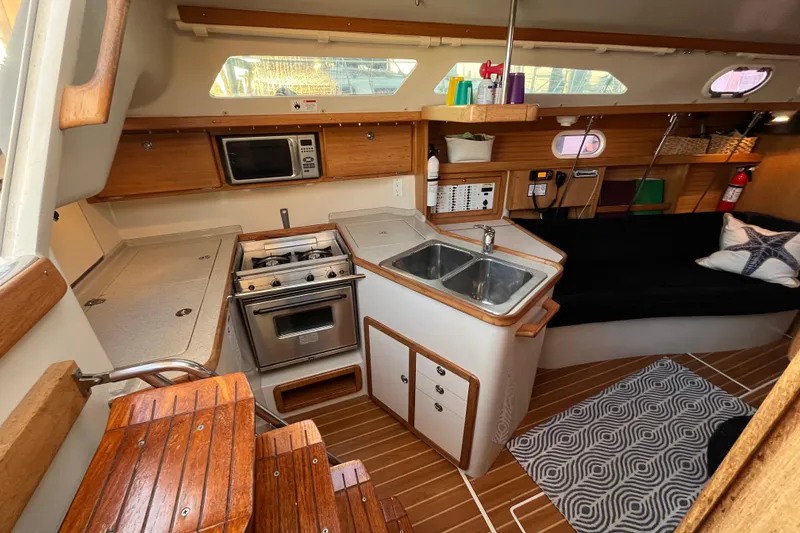 Slide: The Image of Interior of a 2005 Catalina 320 sailboat with kitchen and seating area. - 4