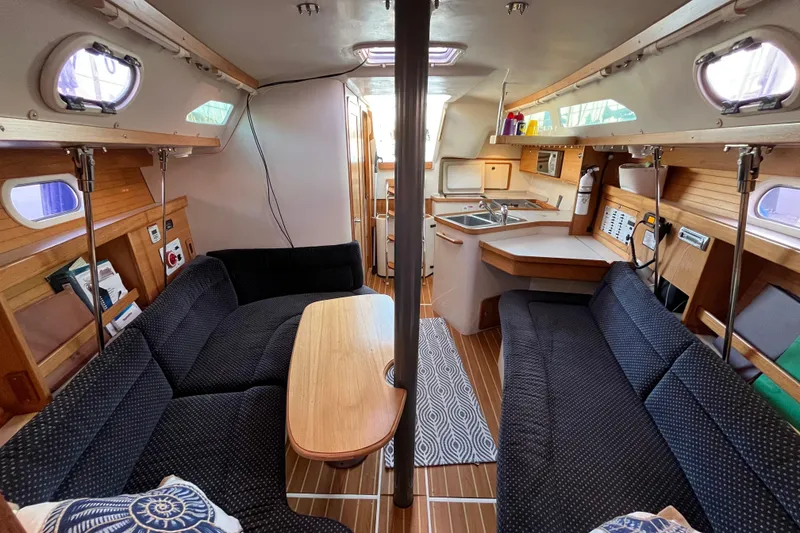 Slide: The Image of Interior of a 2005 Catalina 320 sailboat with cozy seating and a compact kitchen. - 3