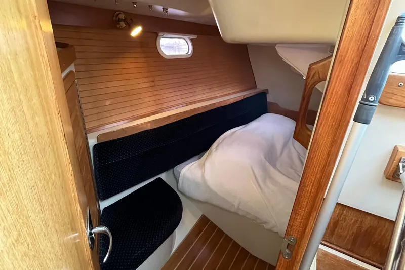 Slide: The Image of Cozy cabin interior of 2005 Catalina 320 sailboat with wooden accents and bedding. - 6